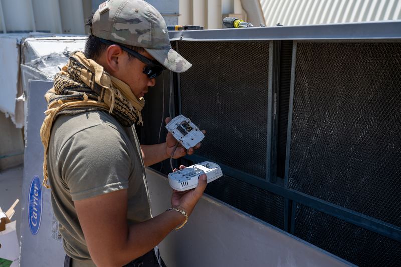 A heating, ventilation and air conditioning technician assigned to the 379th Expeditionary Civil Engineer Squadron inspects a thermostat at an undisclosed location within the U.S. 